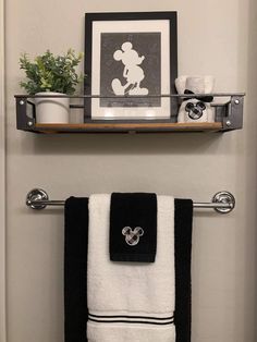 a bathroom with mickey mouse towel rack and black and white towels hanging on the wall