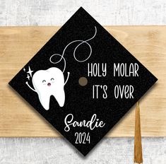 a graduation cap with a tooth on it