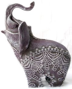 an elephant figurine is shown on a white background