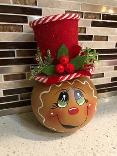 a ceramic pot with a christmas decoration on it's head and holly berries in the top