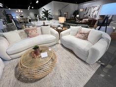 a living room filled with white couches and chairs on top of a carpeted floor