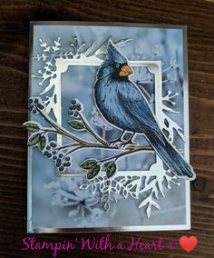 a close up of a card with a bird on a branch and snowflakes