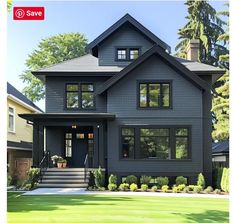 a large gray house with lots of windows on it's front porch and stairs leading up to the second floor