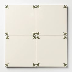 four white tiles with green leaves on them