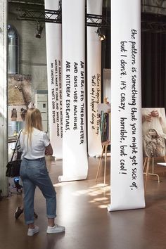 a woman standing in front of white banners with writing on them