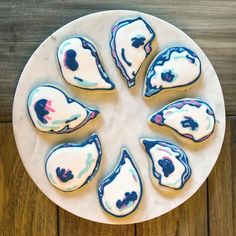 cookies with blue and white icing are arranged on a plate