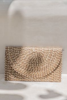 Made with palm leaf and brass Fabric lining 11'' x 7'' Handcrafted in Bali Stylish, sophisticated, and fun, this ombre rattan clutch is an everyday, minimal carrier for your necessities. The interior features a soft fabric lining as well as a change pocket. A vintage inspired piece with a modern and playful twist. Gold Woven Straw Clutch Bag, Gold Straw Clutch Bag For Summer, Beige Rectangular Straw Clutch, Gold Rectangular Beach Clutch, Gold Clutch Straw Bag For Beach, Gold Straw Clutch Bag For The Beach, Gold Clutch Straw Bag For The Beach, Woven Straw Clutch, Natural Clutch With Braided Handles For Summer