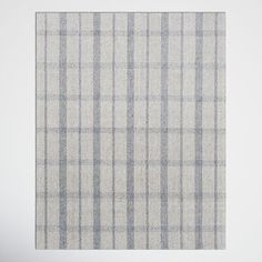 a white and blue checkered rug on top of a wooden floor