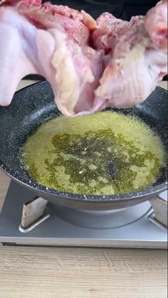 the meat is being cooked in a frying pan on the stove top with pest