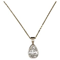 This diamond solitaire necklace exudes classic luxury, showcasing a substantial 1.80ct pear-shaped diamond nestled in a streamlined 14k yellow gold bezel setting for a sleek appearance. The necklace features an impressively sized natural diamond that boasts a great spread, offering the visual grandeur of a conventional 2 carat pear. The J color diamond displays very minimal warmth, presenting a strikingly white appearance against the lustrous yellow gold. Crafted for both beauty and quality, the