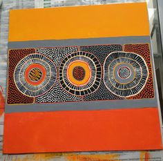 an orange and grey painting with circles on it