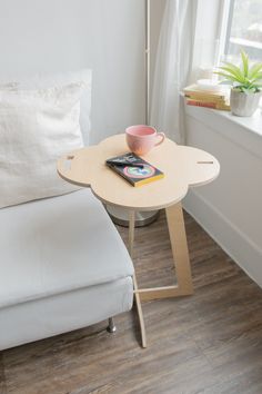 a small table with a cup on it next to a couch