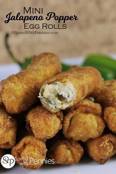 some fried food is on a white plate with green beans and peppers in the background