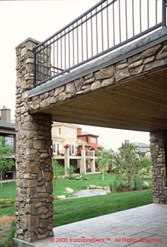 an outdoor patio with stone pillars and railings