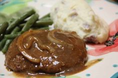 a plate with mashed potatoes, green beans and gravy