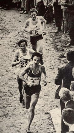 an old photo of two men running in a race with people watching from the sidelines