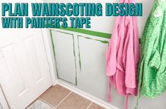 a bathroom with green and pink towels hanging on the wall next to a white door that says plan wainscotting design with painters's tape