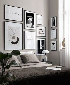 a bed sitting in a bedroom next to a window with pictures on the wall above it