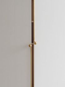 an open door in a white room with gold handles on the handle and bottom panel