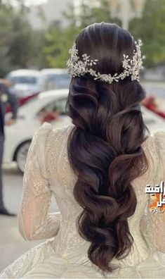 the back of a woman's head with long hair and a tiara on her head