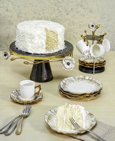 a table topped with plates and cake next to cups