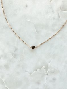 "This is a delicate necklace with black faceted onyx stones secured in the middle of a 14/20 gold-fill, 14/20 rose gold-fill, or Sterling silver chain. You have the option to customize your necklace by selecting either one, two, or three stones to be put on your chain. Pictured: 14\", gold, one bead." Onyx Bead, Onyx Stone, Delicate Necklace, Three Stone, Sterling Silver Chain, Bead Necklace, Sterling Silver Chains, Silver Chain, Arrow Necklace