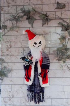 a white and red christmas decoration hanging from a brick wall