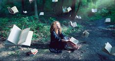 a woman is sitting on the ground with books flying in the air over her head