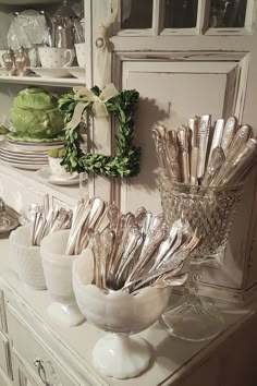 there are many silver spoons in the bowl on the counter next to each other