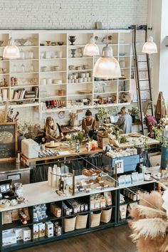 the inside of a store with people working at their desks and shelves full of goods