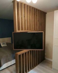 a bed room with a neatly made bed and a flat screen tv mounted to the wall