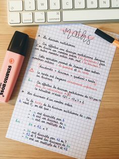 a notepad with writing on it next to a computer keyboard and a pen that says maths