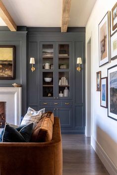 a living room filled with furniture next to a fire place and pictures on the wall