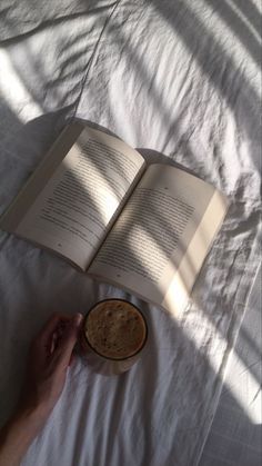 an open book and a bowl on a bed