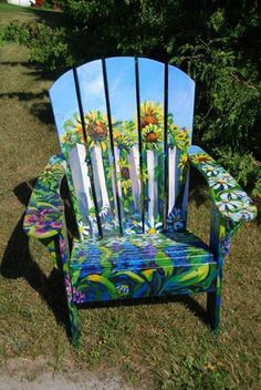 a painted wooden chair sitting in the grass