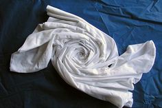 a white cloth is laying on a blue sheet