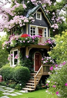 a small house with flowers on the roof and steps leading up to it's second floor