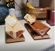 two wooden trays with crackers on them sitting on a counter next to bananas