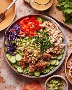 a bowl filled with meat and veggies on top of a table next to bowls of vegetables