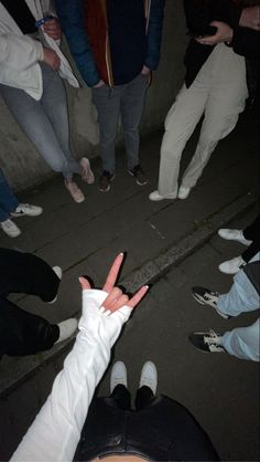 a group of people standing next to each other with their fingers up in the air