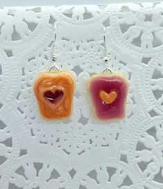 These are cute little PB&J with hearts earrings. :) Handmade by me with polymer clay. They are very lightweight. Choose either silver plated, silver plated surgical steel, or surgical steel fish hooks, gold tone fish hooks, or clip on earrings (silver tone)! Or for a couple dollars extra, you can choose sterling silver flat earwire earring hooks  Not for children under 5. Please note, as these are handmade they may vary slightly. PLEASE READ FOR SHIPPING TIME- MY TURNAROUND TIME right now is app Cute Polymer Clay Earrings For Valentine's Day, Cute Resin Heart Earrings For Valentine's Day, Cute Handmade Heart Earrings For Gift, Polymer Clay Heart Earrings For Valentine's Day Gift, Heart-shaped Polymer Clay Earrings For Gifts, Polymer Clay Heart Earrings As Valentine's Day Gift, Valentine's Day Gift Polymer Clay Heart Earrings, Polymer Clay Heart Earrings As Gift, Valentine's Day Gift Kawaii Heart Earrings