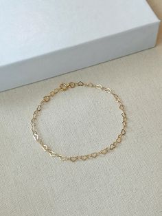 Hearts are melting for this dainty yet durable mini heart chain bracelet! 💛 This unique chain is sensitive skin and water safe, and is made to live your life in! Wear this minimal piece to brunch, or on a date... this simple heart chain looks lovely anywhere you take it! Details: * 3.5mm 14K Gold Filled heart chain * Dainty 14K Gold Filled spring clasp * 14/20 gf stamp for authenticity * Choose your length (each bracelet comes with a .5" extender chain for adjustable sizing.) * Made with all hypoallergenic and water safe materials 🤍 ✨ Pairs well with the Mini Heart Chain Necklace https://etsy.me/40aqcLB BRACELET MEASURING GUIDE: Average Women's Sizing: 5-6 inches = xtra small 6.5-7 inches = small 7-8 inches = medium 8 inches+ = large Please make sure to measure to get the right fit! Each Minimalist Gold Bracelet, Heart Chain Bracelet, Bracelet Love, Bracelet Minimalist, Basic Jewelry, Gold Armband, Heart Chain, Love Bracelet, Keepsake Jewelry