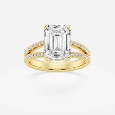 an emerald cut engagement ring with diamond accents on the band and side stones in 18k yellow gold