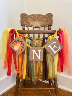 a wooden chair with colorful streamers hanging from it's legs and the letters n e