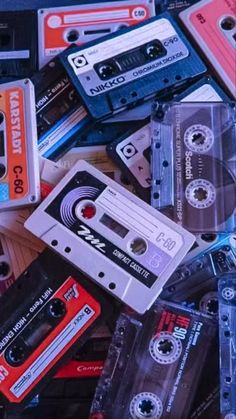 an assortment of old and used cassettes are piled on top of each other in this image