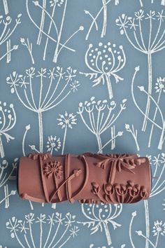 a chocolate candy bar with the word love on it sitting in front of a blue floral wallpaper