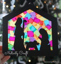 a paper cut christmas ornament with a nativity scene in the center and a tree behind it