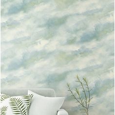 a living room scene with focus on the couch and wallpaper that looks like clouds