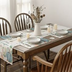 a dining room table set with place settings