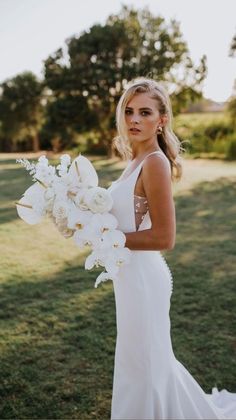 a woman in a white dress holding a bouquet of flowers